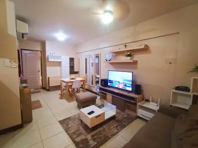 a living room with a couch and a tv and a table at Available Resort Type Condo Unit in Manila