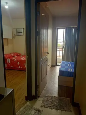 a room with a door and a bedroom with a bed at Available Resort Type Condo Unit in Manila