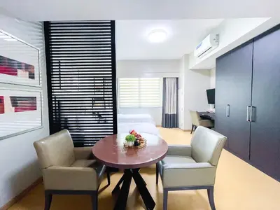 a living room with a dining room table and chairs at Hotel like unit The Avant at the Fort in Manila