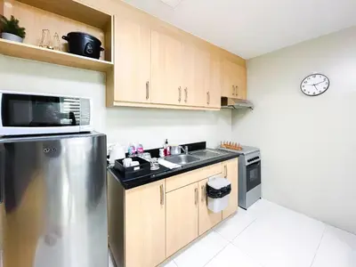 a kitchen with a sink and a refrigerator at Hotel like unit The Avant at the Fort in Manila