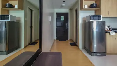 a hallway of a kitchen with a large refrigerator at Hotel like unit The Avant at the Fort in Manila