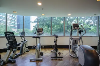 a gym with cardio machines in front of a window at Hotel like unit The Avant at the Fort in Manila