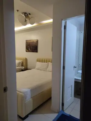 a bedroom with a bed and a ceiling fan at Need Place To Stay Booked Now Manila with Balcony Sea View, Promo Discount, Free Pool Plus Free Sauna Access Steps Away US Embassy, Updated 2026 Prices - Hurry Limited Time Only in Manila