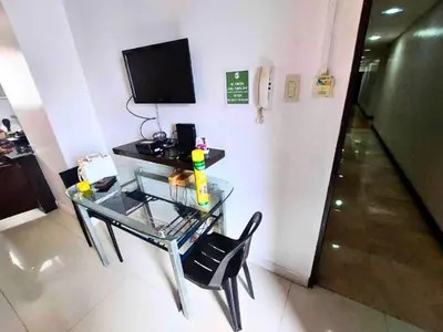 a glass table with a chair and a television in a room at Need Place To Stay Booked Now Manila with Balcony Sea View, Promo Discount, Free Pool Plus Free Sauna Access Steps Away US Embassy, Updated 2026 Prices - Hurry Limited Time Only in Manila