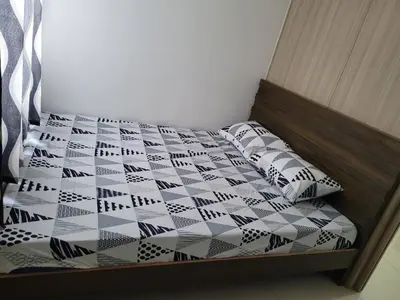 a bed with a black and white quilt and pillows at Shore residences Ph in Manila