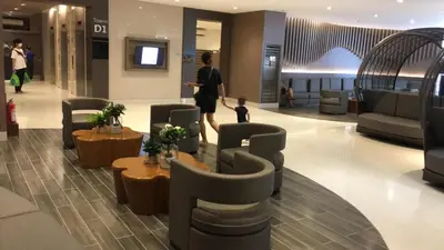 a woman and a child walking through a lobby at Shore residences Ph in Manila