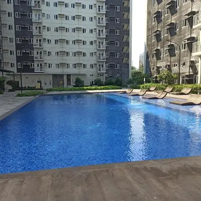 a swimming pool in the middle of two tall buildings at Avery's Place SMDC CHARM in Manila