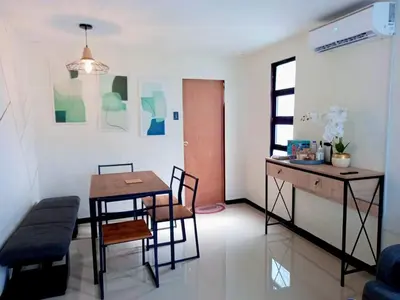a living room with a table and chairs and a desk at Sönmez Private Villa in Cavite