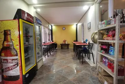 an empty restaurant with a bottle of beer on the refrigerator at Sunny Day Residences Cainta in Cainta