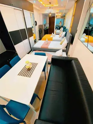 a room with four beds and a table and chairs at Shell Family Suites Ocean & MOA view in Manila