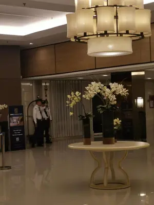 a table with vases of flowers on it in a lobby at Shell Family Suites Ocean & MOA view in Manila