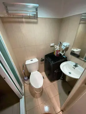a bathroom with a white toilet and a sink at Shell Family Suites Ocean & MOA view in Manila