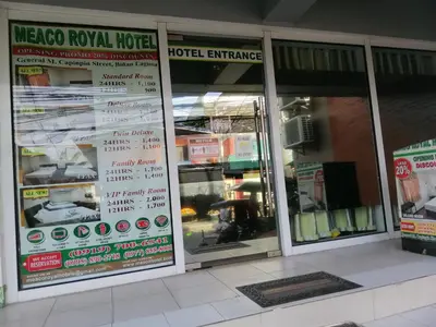 three windows of a hotel entrance with signs on them at Meaco Royal Hotel - Biñan Laguna in Biñan