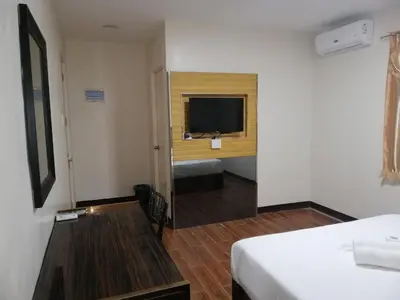 a hotel room with a bed and a flat screen tv at Meaco Royal Hotel - Biñan Laguna in Biñan