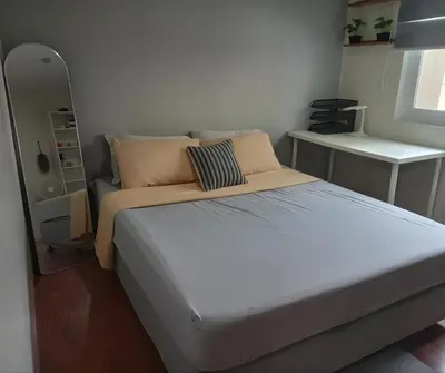 a bedroom with a large bed and a mirror at CB Homestay 2BR Unit Taguig Self-Check-In & Wi-Fi in Manila
