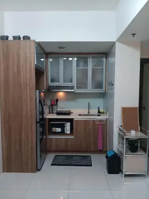 a kitchen with wooden cabinets and a sink at CB Homestay 2BR Unit Taguig Self-Check-In & Wi-Fi in Manila