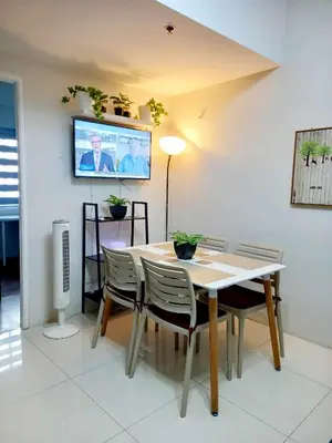 a dining room with a table and chairs and a tv at CB Homestay 2BR Unit Taguig Self-Check-In & Wi-Fi in Manila