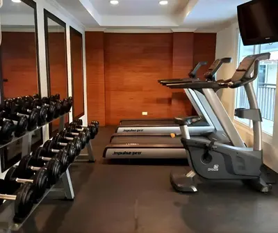 a gym with a bunch of treadmills at CB Homestay 2BR Unit Taguig Self-Check-In & Wi-Fi in Manila