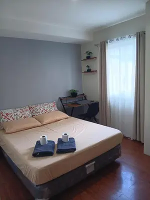 a bedroom with a bed with two towels and two cups at CB Homestay 2BR Unit Taguig Self-Check-In & Wi-Fi in Manila