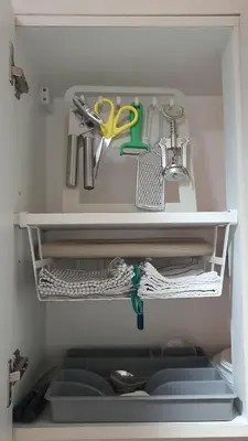 a white shelf with some kitchen utensils and scissors at The New Villa at Sea Residences in Manila