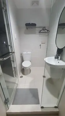 a bathroom with a toilet and a sink at The New Villa at Sea Residences in Manila