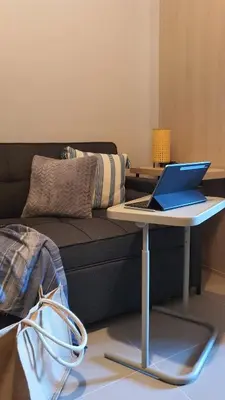 a laptop sitting on a table in front of a couch at The New Villa at Sea Residences in Manila