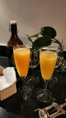 two glasses of orange juice on a table at The New Villa at Sea Residences in Manila