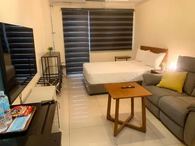 a small living room with a bed and a couch at Shell Residences Mall of Asia Pasay in Manila