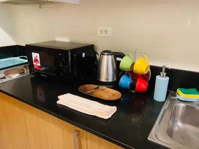 a kitchen counter with a microwave and a sink at Shell Residences Mall of Asia Pasay in Manila