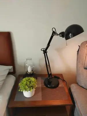 a desk with a lamp and a plant on a table at Shell Residences Mall of Asia Pasay in Manila