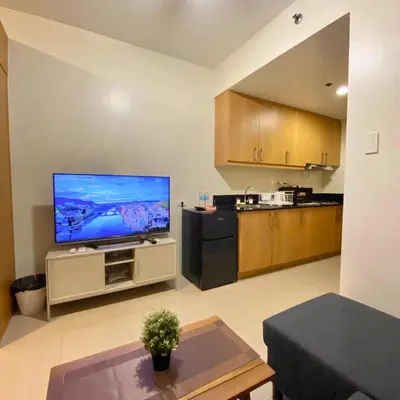 a living room with a large flat screen tv at Shell Residences Mall of Asia Pasay in Manila