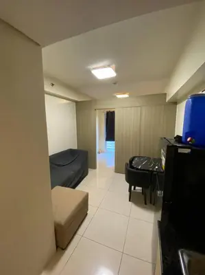 a small living room with a couch and a table at Breeze Residences 26th floor in Manila