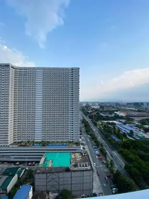 a view of a large building and a highway at Breeze Residences 26th floor in Manila