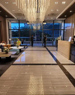 a lobby with a large chandelier in a building at Uptown Parksuites Tower 1 at BGC - Staycations Up Above 12 in Manila