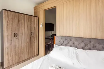 a bedroom with a bed and a large wooden cabinet at BTS Be The Ace at MOA in Manila
