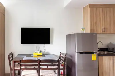a kitchen with a table and a refrigerator at BTS Be The Ace at MOA in Manila