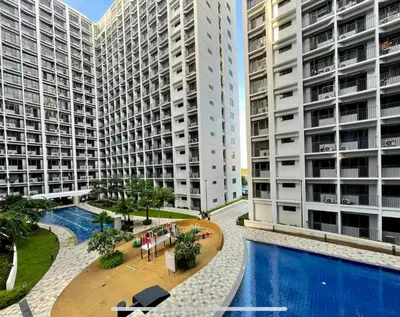 a view of two tall buildings and a swimming pool at BTS Be The Ace at MOA in Manila
