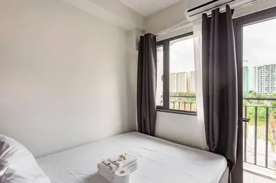 a small bedroom with a bed and a window at BTS Be The Ace at MOA in Manila