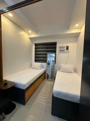 two beds in a small room with a mirror at M&Ms Place in Dasmariñas