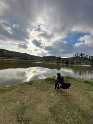a person sitting in a chair in front of a lake at M&Ms Place in Dasmariñas