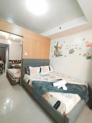 a bedroom with two beds and a mirror at Shell Residences MOA 3 in Manila
