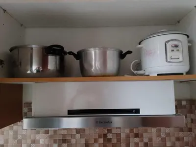 a stove top with pots and a toaster on a shelf at Shell Residences MOA 3 in Manila