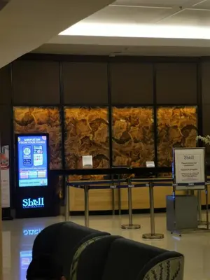a stone wall in a building with a tv at Shell Residences MOA 3 in Manila