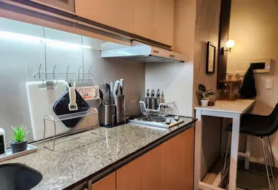 a kitchen with a sink and a counter top at LUXESTAYSMNL ELEGANT FAMILY 2BR SUITE POOLGYM 400MBPS WIFI NETFLX AMAZING CITY VIEW in Manila