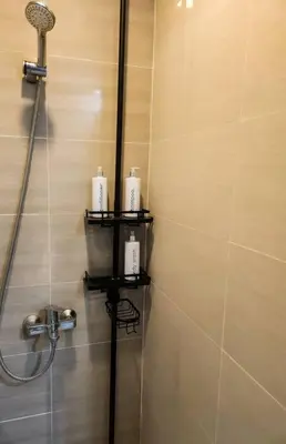 a bathroom with a shower with three candles on shelves at LUXESTAYSMNL ELEGANT FAMILY 2BR SUITE POOLGYM 400MBPS WIFI NETFLX AMAZING CITY VIEW in Manila