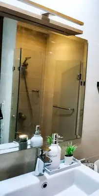 a bathroom sink with a mirror and a shower at LUXESTAYSMNL ELEGANT FAMILY 2BR SUITE POOLGYM 400MBPS WIFI NETFLX AMAZING CITY VIEW in Manila