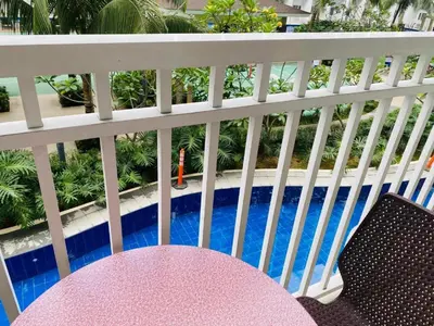 a pink table and chairs on a balcony with a pool at SHORE RESIDENCE D14 shortwalk Mall of asia near airport in Manila