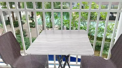 a white table and chairs on a balcony at SHORE RESIDENCE D14 shortwalk Mall of asia near airport in Manila