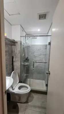 a bathroom with a shower and a toilet and a sink at Affordable Condo in Makati w/ Wi-Fi, Netflix, Pool in Manila