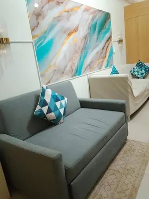 a living room with a couch and a painting at Shell Residences 2BR & 2CR 101D in Manila